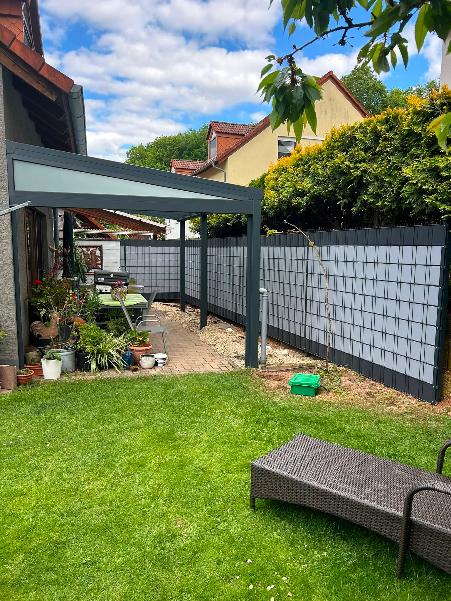 Anthrazitfarbener Sichtschutzzaun neben einem modernen Terrassendach.